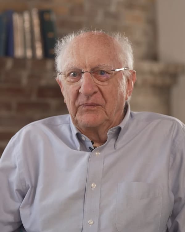 John Clarke, idoso, de óculos e camisa azul
