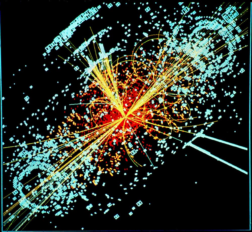 Imagem de computador de uma colisão de partículas: linhas amarelas e vermelhas saindo do centro, cercadas de quadradinhos azuis