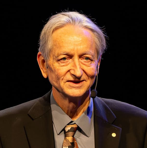 Geoffrey Hinton num palco, de terno
