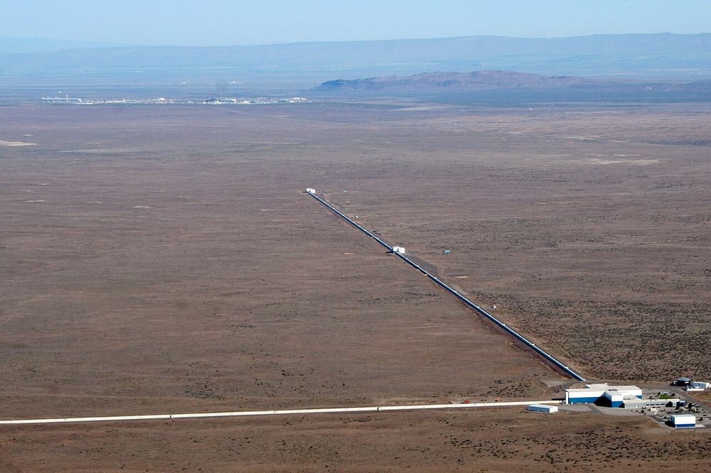 Vista aérea do observatório LIGO no deserto: dois braços retos de 4 km saindo de um prédio