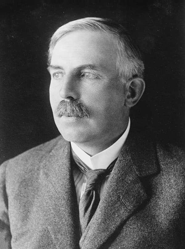 Retrato de Ernest Rutherford, de bigode, olhando para o lado