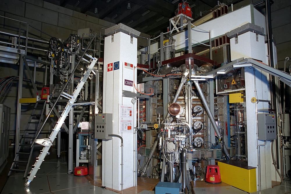 Reator de fusão TCV, cercado de cabos, tubos e escadas, num laboratório