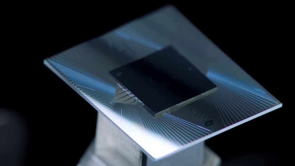Chip quântico Sycamore, um quadrado escuro sobre uma placa metálica com linhas finas