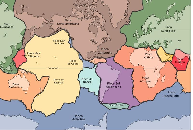 Mapa-múndi com as placas tectônicas pintadas de cores diferentes e os nomes em português
