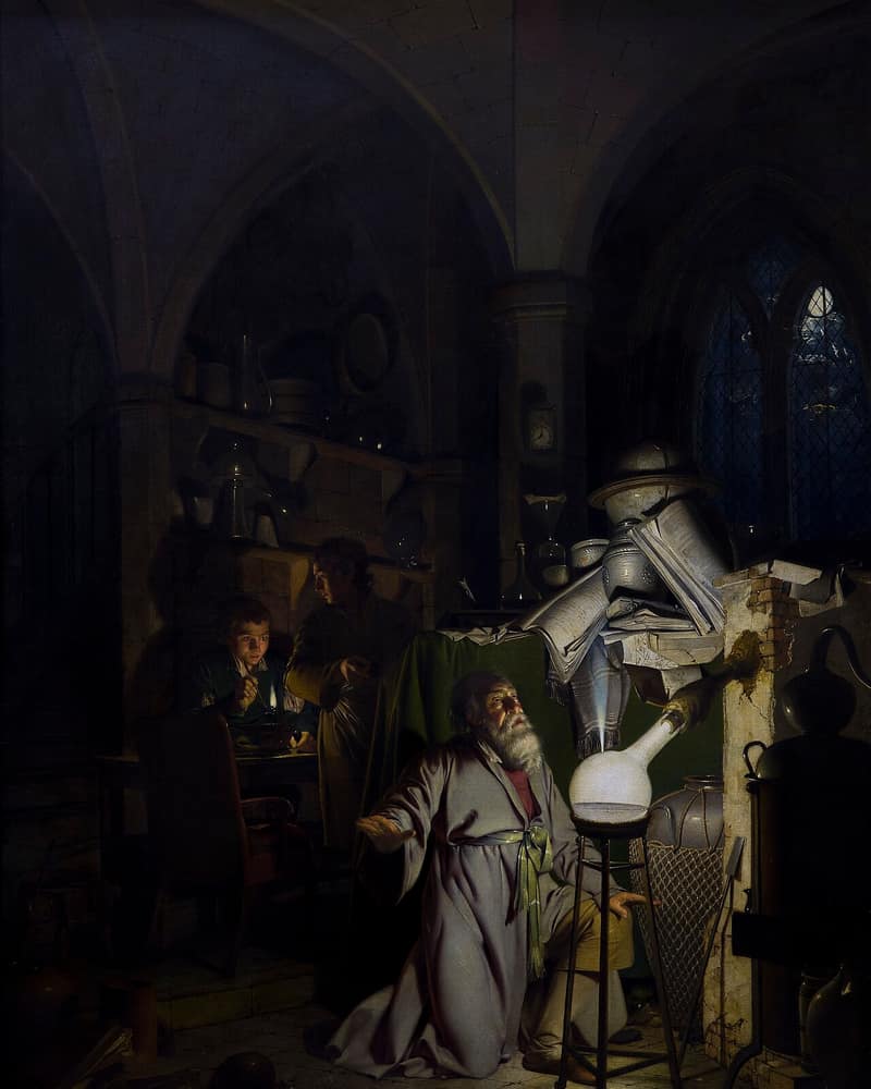 Pintura de um alquimista ajoelhado diante de um frasco que brilha, num laboratório escuro