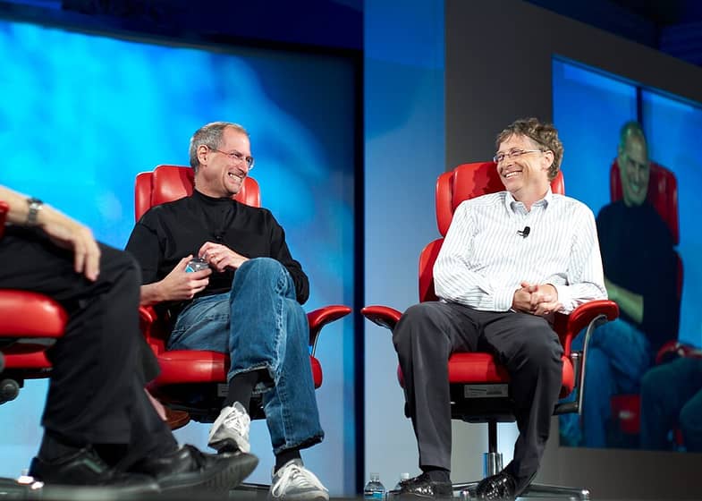 Steve Jobs e Bill Gates sentados lado a lado numa conferência em 2007
